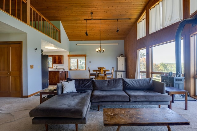 carpeted living room with a chandelier, high vaulted ceiling, a healthy amount of sunlight, and wood ceiling