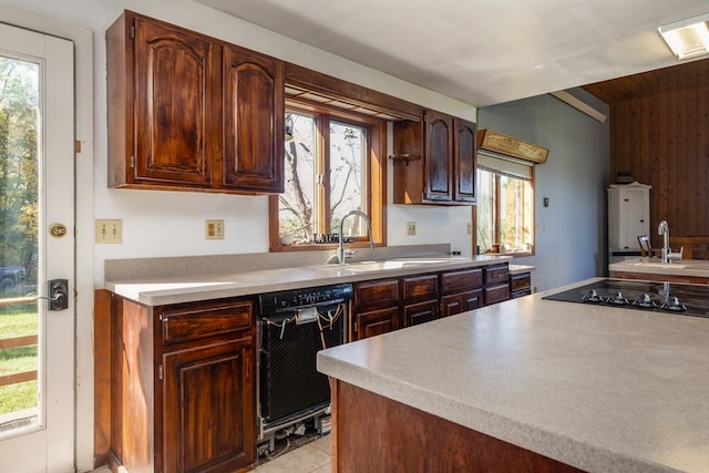 kitchen featuring black appliances, dark brown cabinetry, light tile patterned floors, and sink