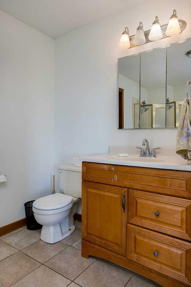 bathroom with tile patterned floors, vanity, toilet, and a shower with shower door