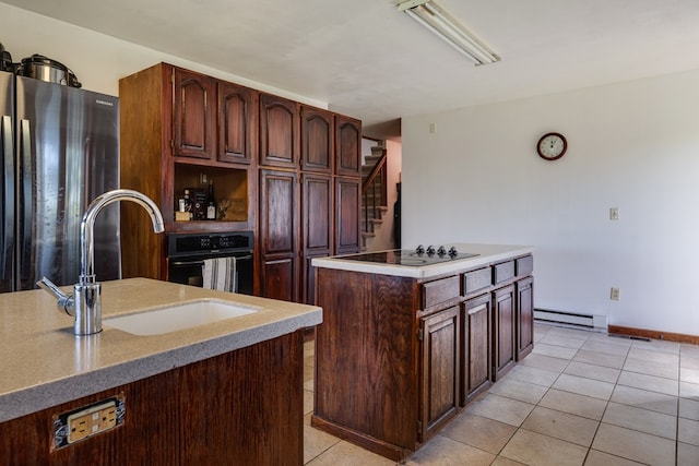 kitchen with a kitchen island with sink, sink, light tile patterned floors, and black appliances