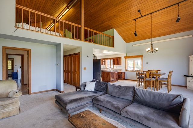 living room with wooden ceiling, light carpet, a high ceiling, and a chandelier