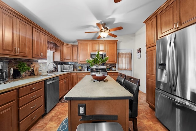4060 Wilawana Rd, Sayre, PA 18840 - kitchen with appliances with stainless steel finishes, a ceiling fan, backsplash, and brown cabinetry
