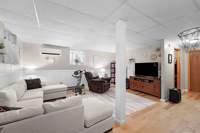4060 Wilawana Rd, Sayre, PA 18840 - living room with a wall unit AC, light wood-style floors, a drop ceiling, and wainscoting