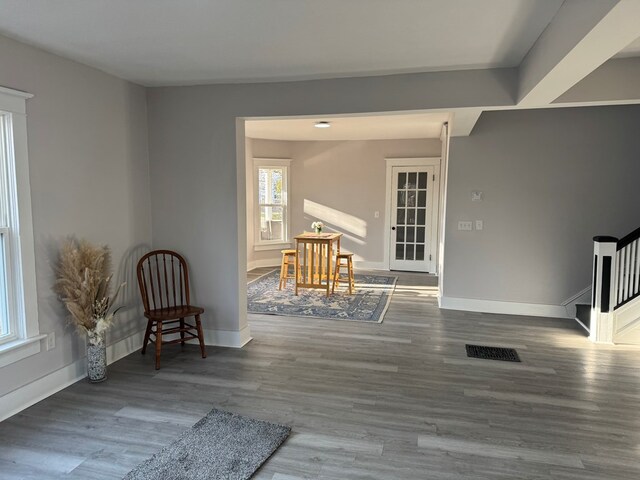 unfurnished room with stairs, visible vents, wood finished floors, and baseboards