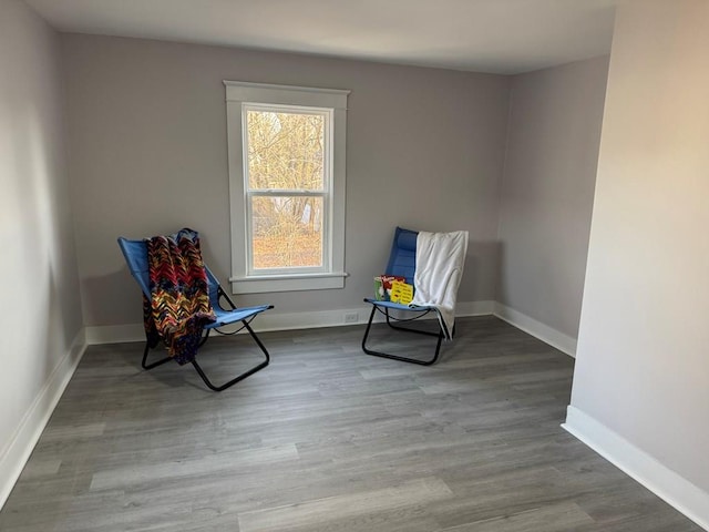 living area featuring baseboards and wood finished floors