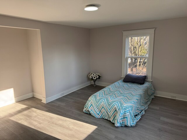 bedroom featuring baseboards and wood finished floors