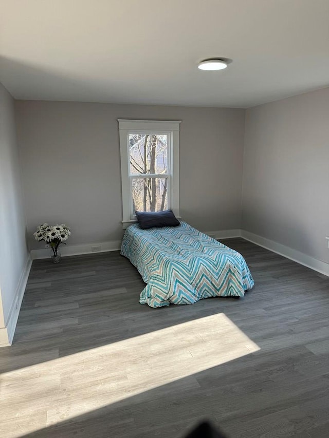 bedroom featuring wood finished floors and baseboards