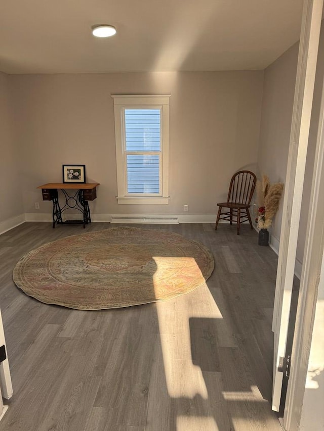 interior space featuring a baseboard radiator, baseboards, and wood finished floors