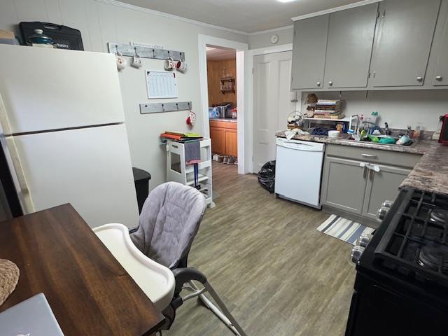 kitchen with gray cabinetry, sink, ornamental molding, white appliances, and light wood-type flooring