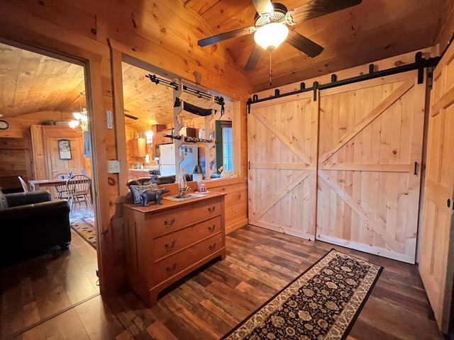 interior space featuring a barn door, wood ceiling, wood walls, and vaulted ceiling