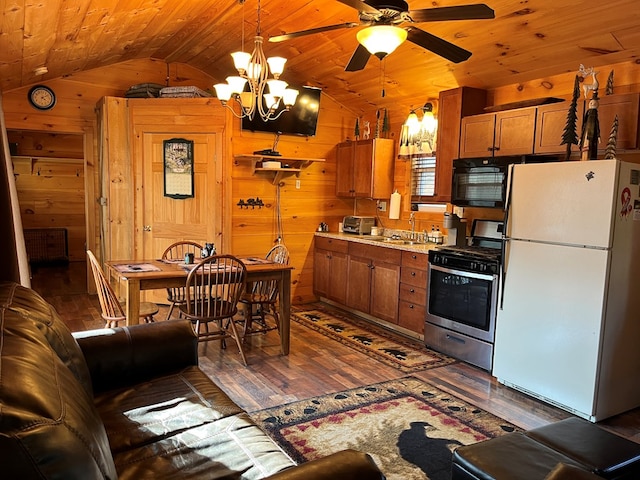 kitchen featuring wooden walls, stainless steel range with gas stovetop, freestanding refrigerator, wood ceiling, and black microwave