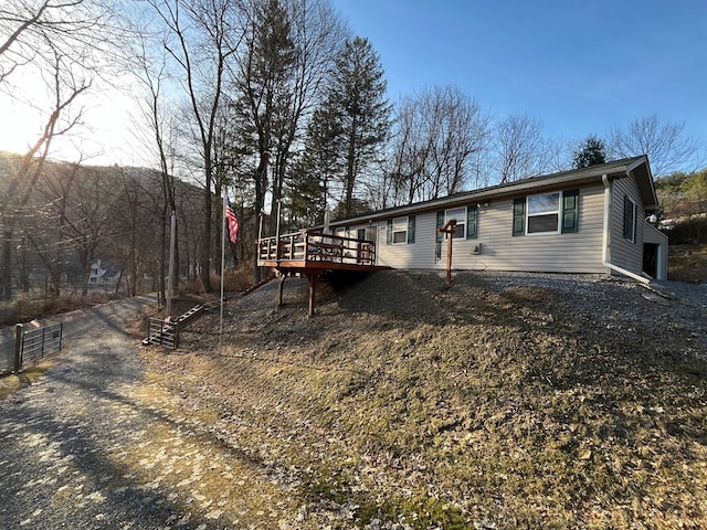 ranch-style home with a wooden deck and fence