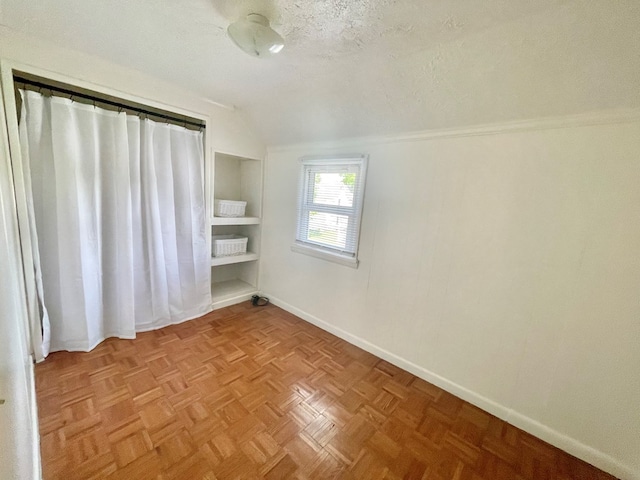 114 Elsbree St, Sayre, PA 18840 - spare room with vaulted ceiling, built in features, baseboards, and a textured ceiling