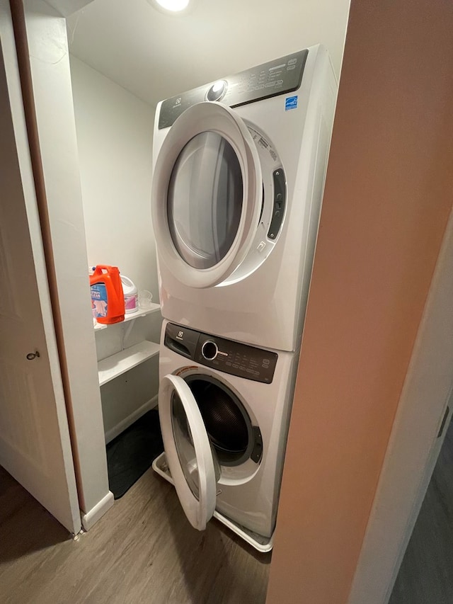 washroom featuring light wood-type flooring and stacked washing maching and dryer