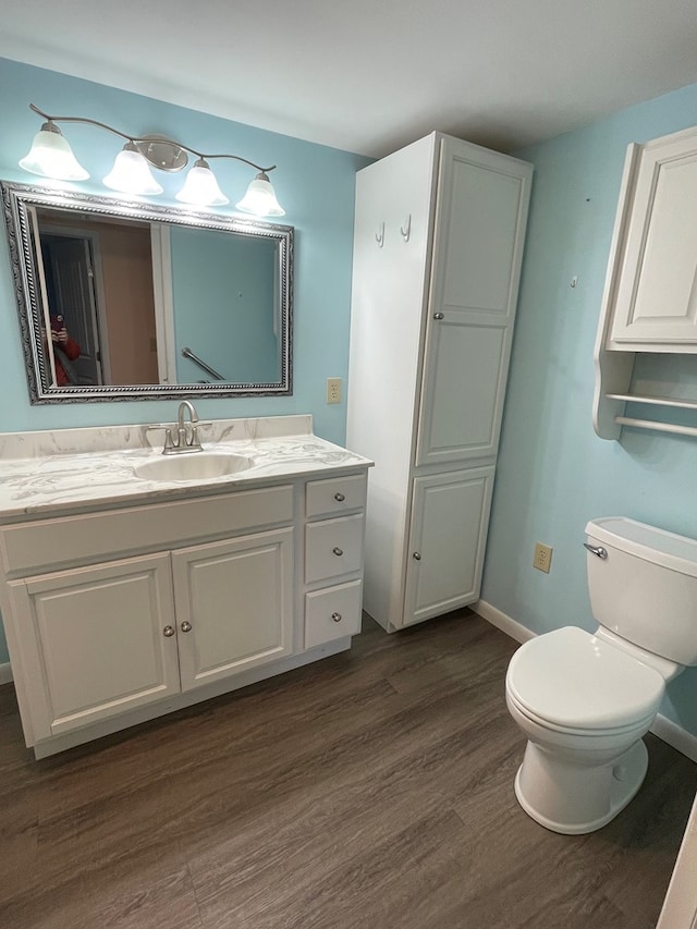 bathroom featuring toilet, vanity, and hardwood / wood-style flooring