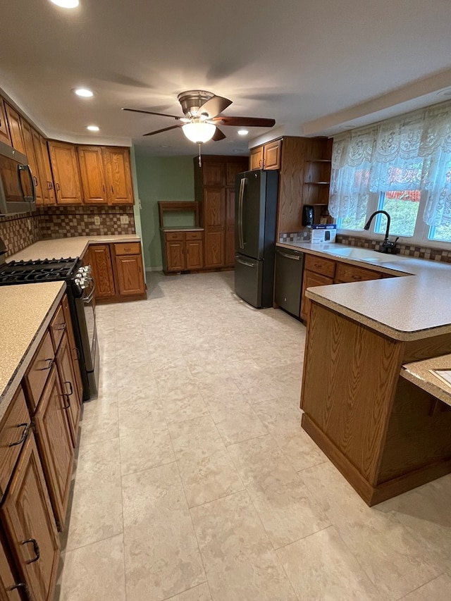 kitchen featuring ceiling fan, decorative backsplash, sink, and appliances with stainless steel finishes