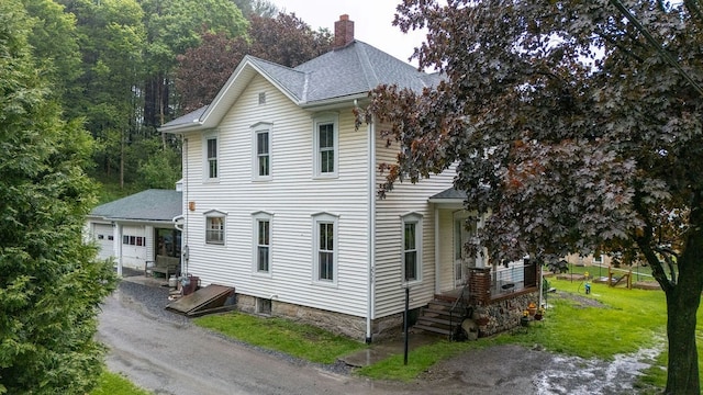 2779 Stony Fork Rd, Wellsboro, PA 16901 - view of property exterior featuring a chimney, asphalt driveway, a shingled roof, a yard, and a garage