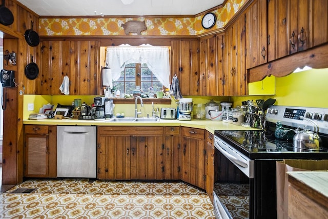 2779 Stony Fork Rd, Wellsboro, PA 16901 - kitchen featuring appliances with stainless steel finishes, a sink, light countertops, brown cabinetry, and crown molding