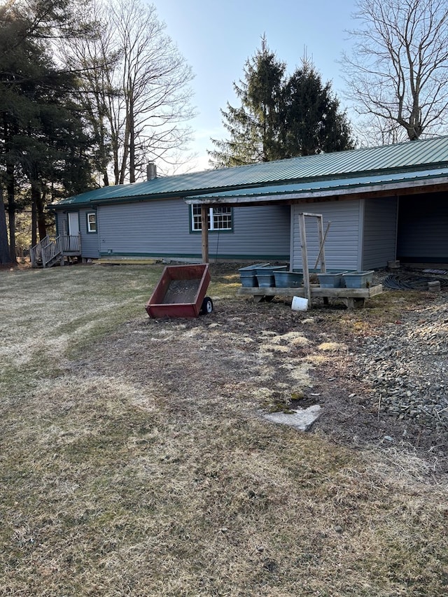 rear view of property with a chimney and metal roof