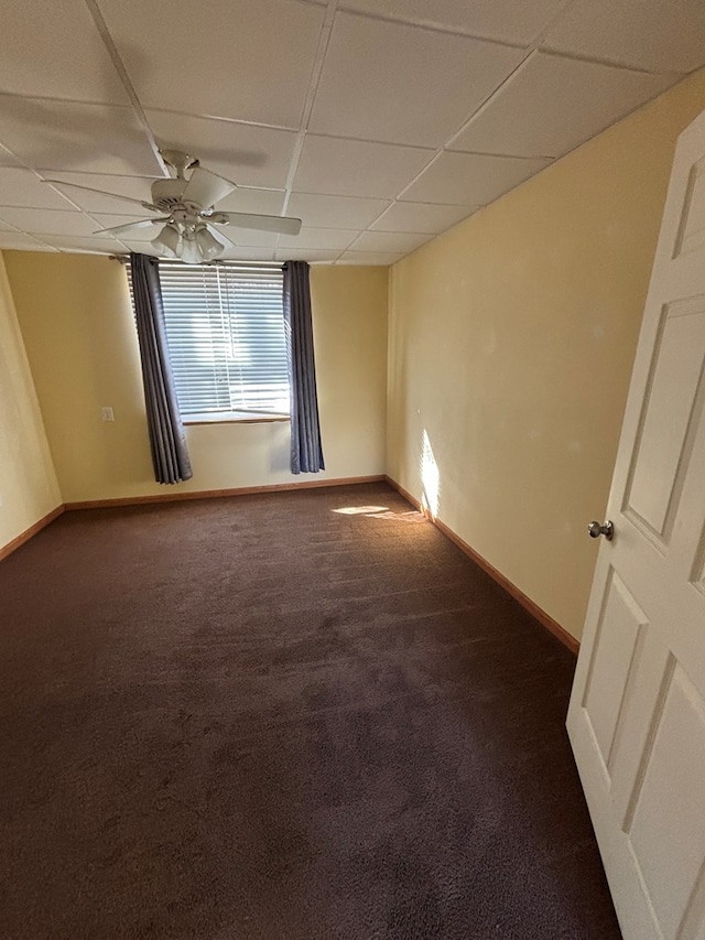 carpeted spare room with a paneled ceiling and baseboards