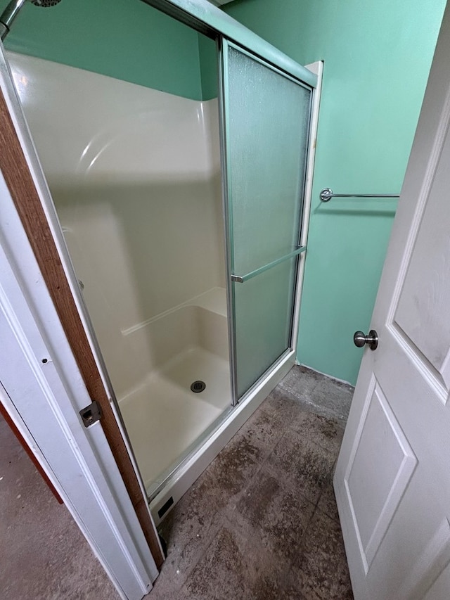 bathroom featuring a shower with door