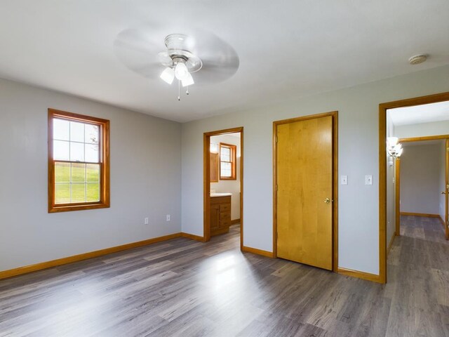 unfurnished bedroom with hardwood / wood-style flooring, ceiling fan, and ensuite bathroom