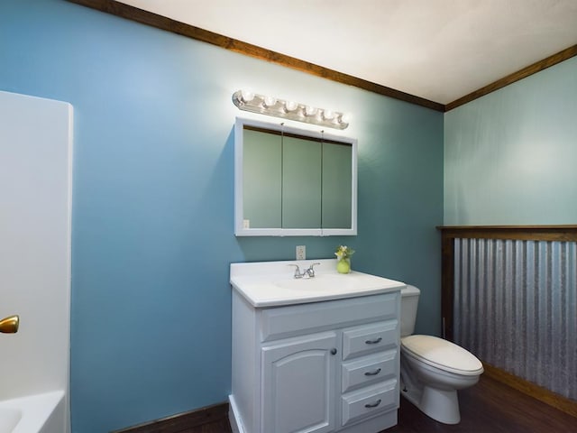 bathroom featuring a tub, hardwood / wood-style flooring, vanity, and toilet