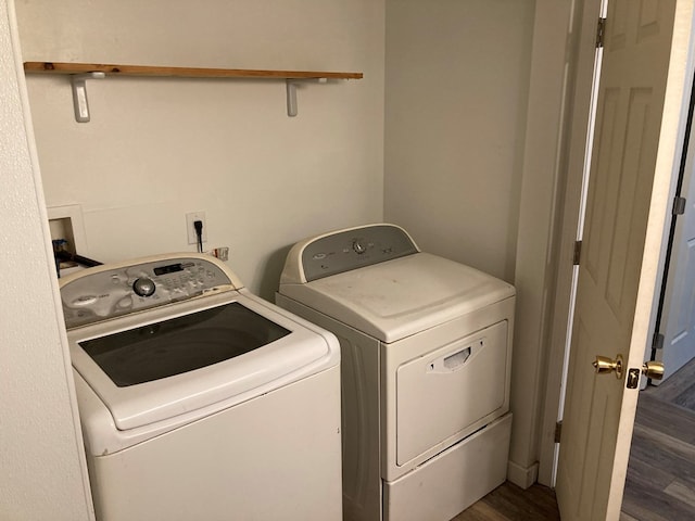 washroom with separate washer and dryer and dark wood-type flooring