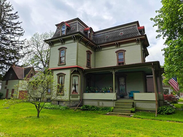 440 Park Ave, Waverly, NY 14892 - victorian home with mansard roof, a front lawn, and a porch