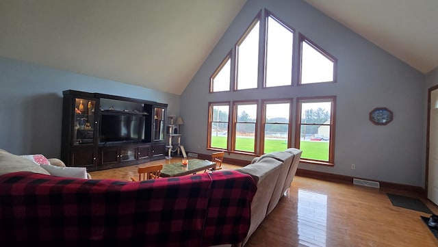 8065 Rte 414, Liberty, PA 16930 - living area featuring high vaulted ceiling, visible vents, baseboards, and wood finished floors