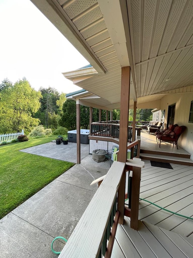 view of patio / terrace with a hot tub and a deck