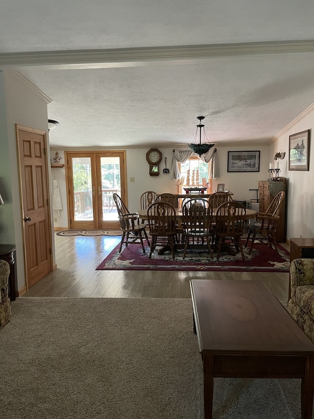 dining area featuring plenty of natural light, dark hardwood / wood-style flooring, ornamental molding, and french doors