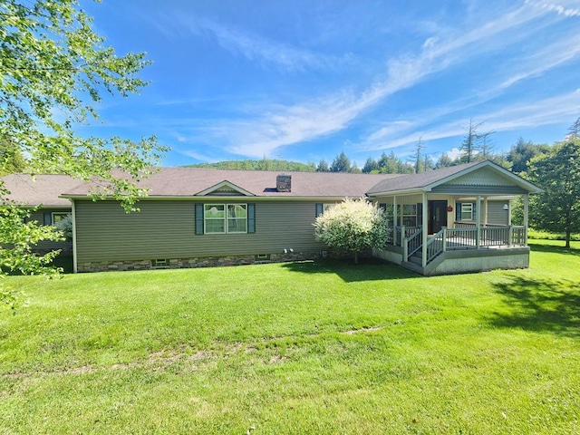 back of property with a porch and a lawn