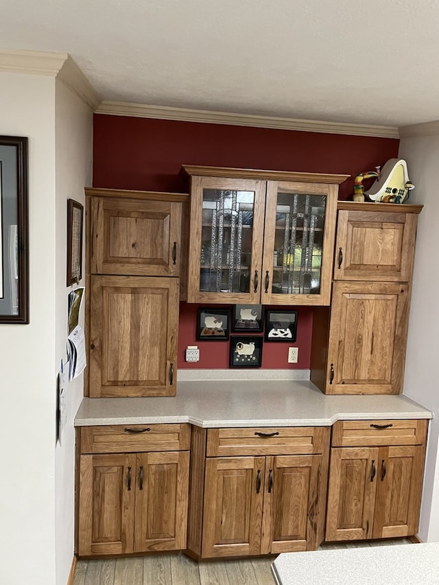 bar featuring light wood-type flooring and crown molding