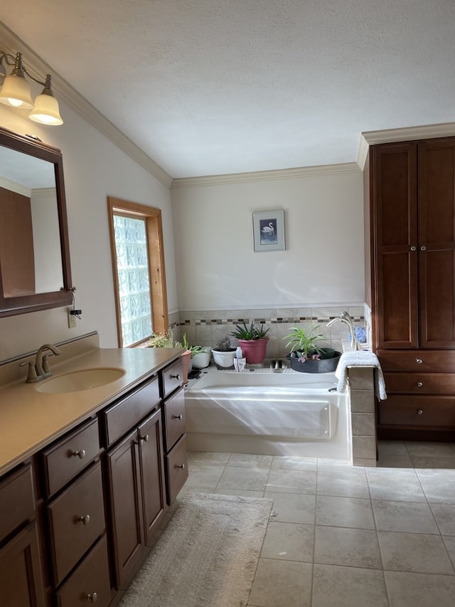 bathroom with a washtub, vanity, vaulted ceiling, and ornamental molding