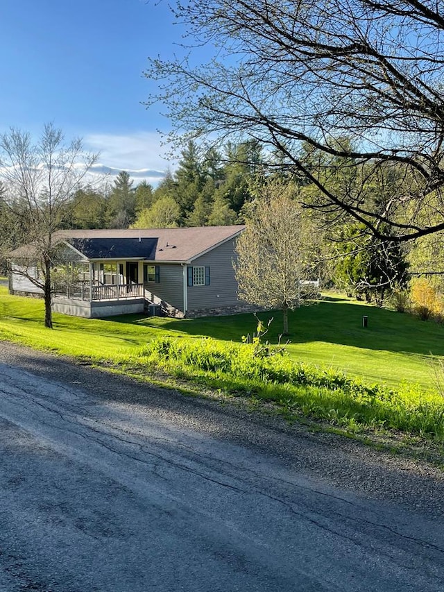 view of side of property with covered porch and a yard