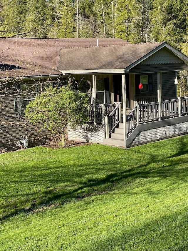 back of property featuring covered porch and a yard