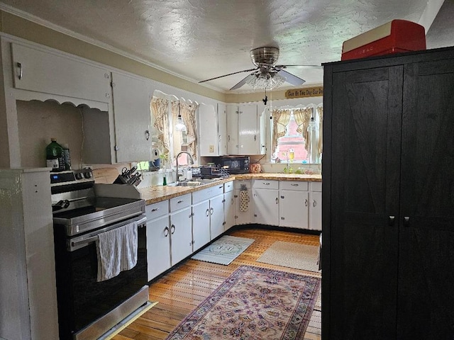 409 E Main St, Elkland, PA 16920 - kitchen with electric range, plenty of natural light, light wood finished floors, crown molding, and a textured ceiling