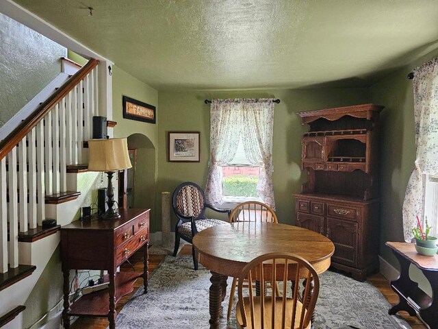 409 E Main St, Elkland, PA 16920 - dining space featuring stairway, wood finished floors, a textured ceiling, and arched walkways
