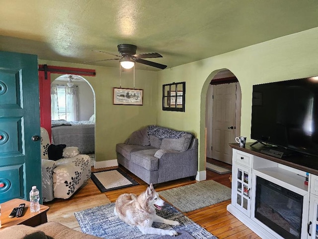409 E Main St, Elkland, PA 16920 - living room with arched walkways, ceiling fan, light wood finished floors, and baseboards