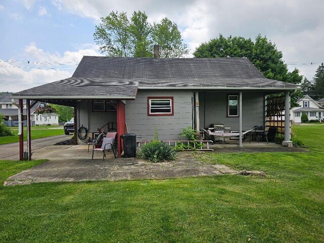 409 E Main St, Elkland, PA 16920 - rear view of property with a lawn, an attached carport, a shingled roof, and a patio