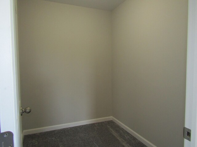 spare room featuring dark colored carpet