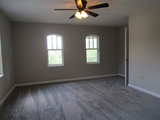 carpeted empty room featuring ceiling fan and a textured ceiling