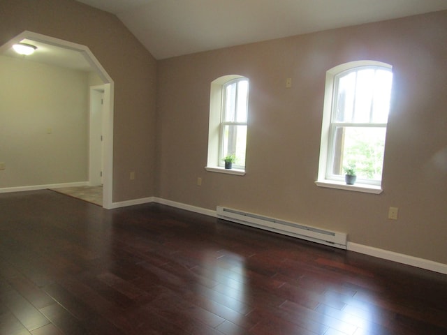 spare room with dark hardwood / wood-style floors, vaulted ceiling, and a baseboard radiator