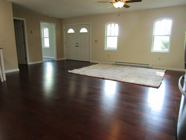 foyer entrance featuring a baseboard heating unit, dark wood-type flooring, and ceiling fan