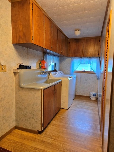 laundry room featuring light wood-type flooring, cabinets, and sink