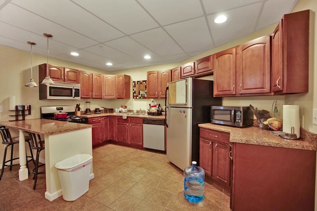 kitchen featuring a kitchen breakfast bar, decorative light fixtures, stainless steel appliances, kitchen peninsula, and light stone countertops