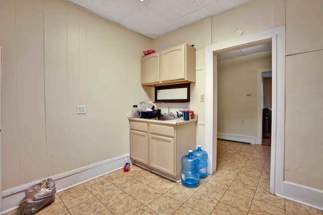 kitchen featuring light tile patterned flooring, baseboard heating, sink, and light brown cabinetry