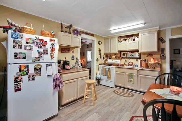 kitchen featuring light wood-type flooring, cream cabinets, sink, ornamental molding, and white appliances