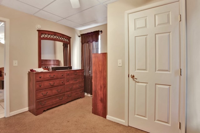 hallway with light colored carpet and a drop ceiling